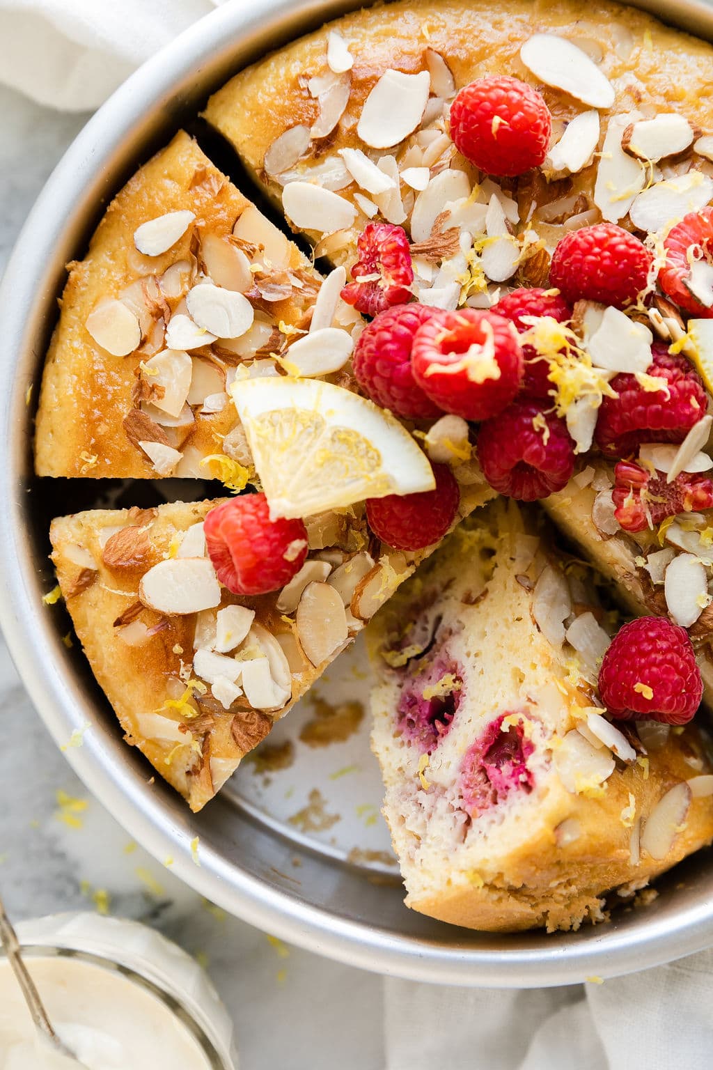 Overhead view of Raspberry Coffee Cake with Lemon sliced in a baking pan.