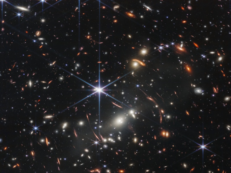 An image of a part of the universe showing distant galaxies. There are a large number of distant galaxies and star clusters on the image, taken from the James Webb Space Telescope.