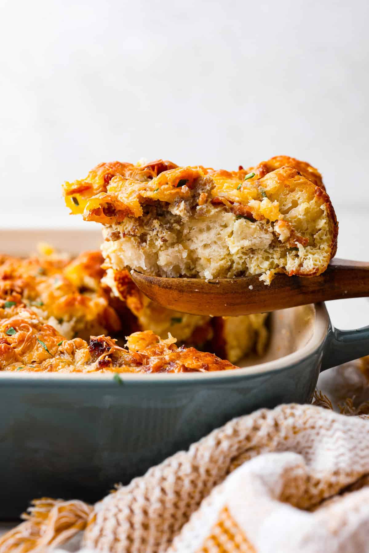 Side shot of a serving of bubble up breakfast casserole being taken out of the baking dish.