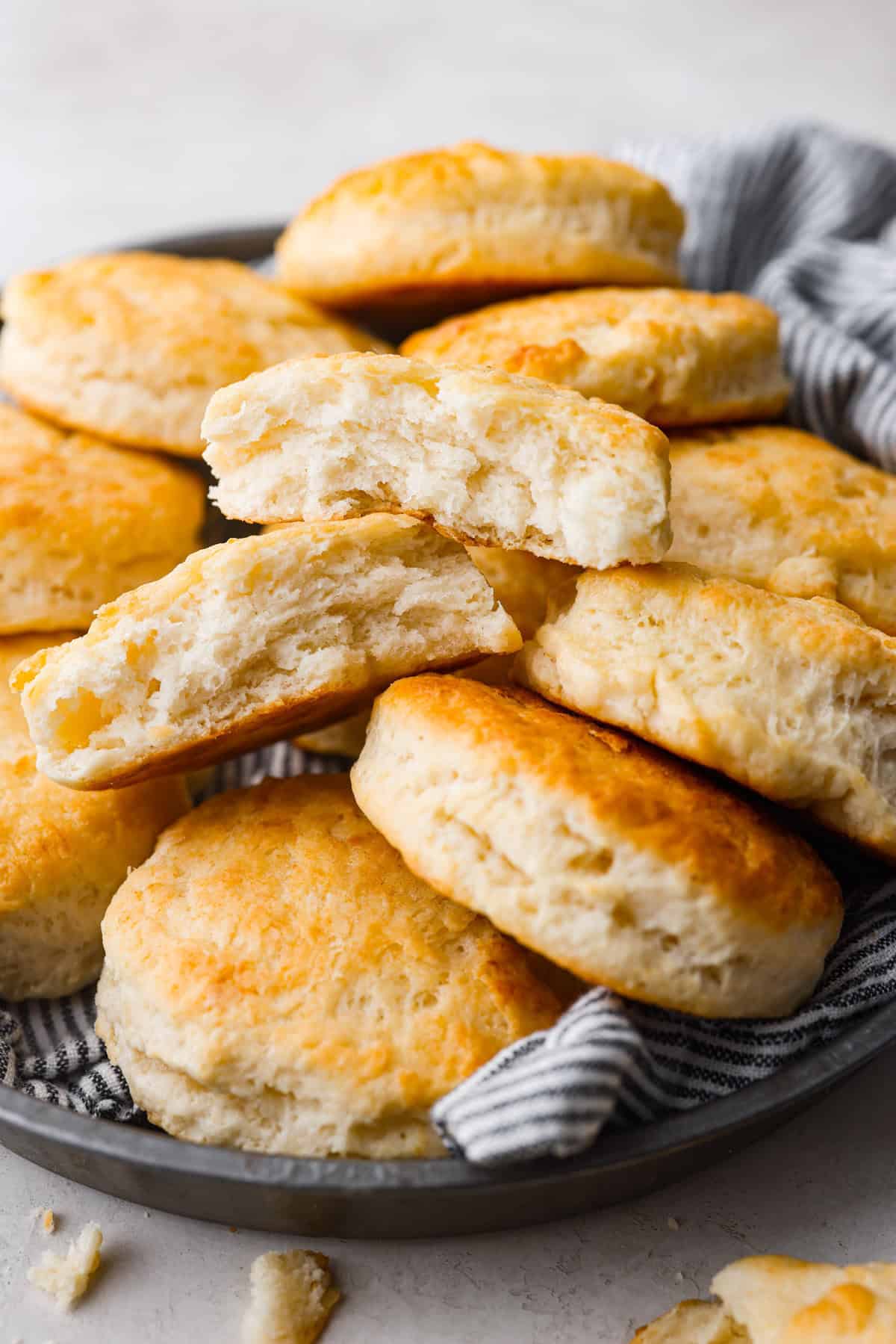 Angle shot of cream cheese biscuits stacked on a plate.