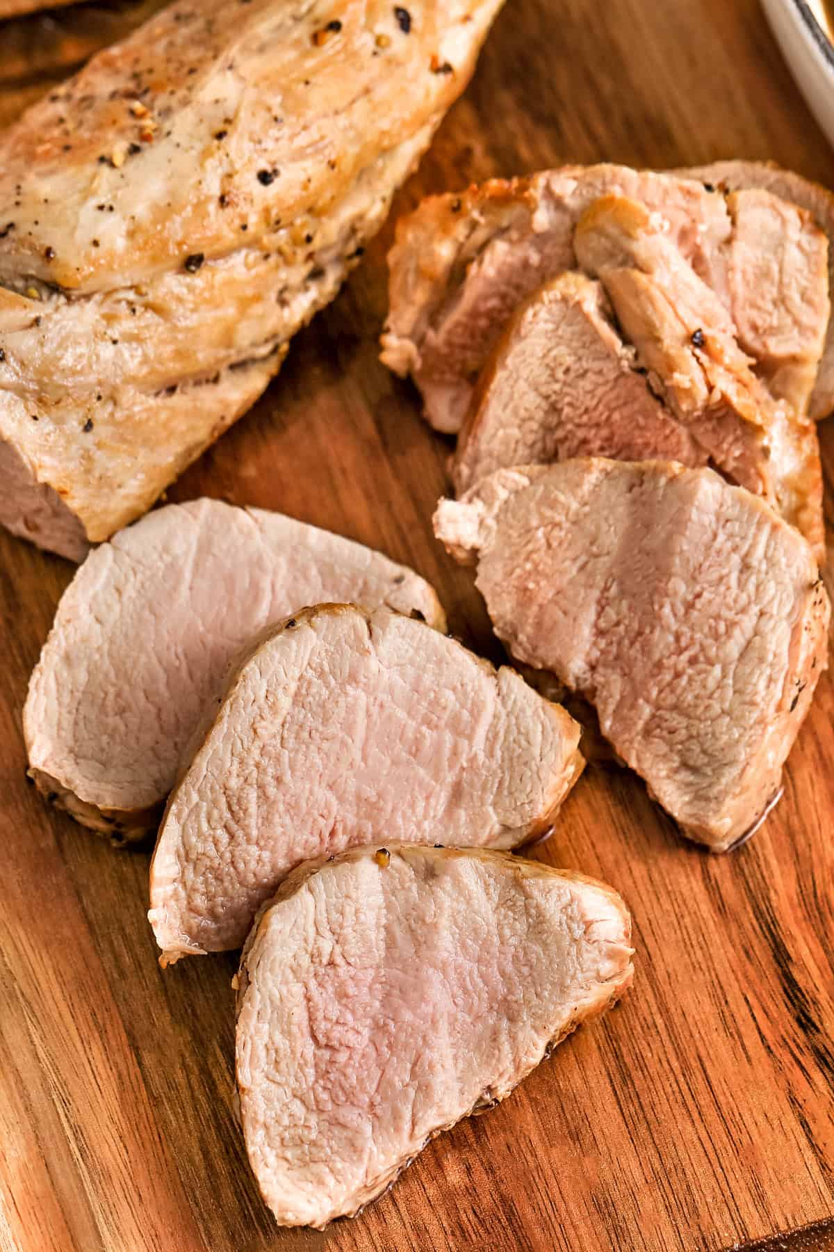 sliced Pork Tenderloin on a cutting board to show How to Cook Pork Tenderloin