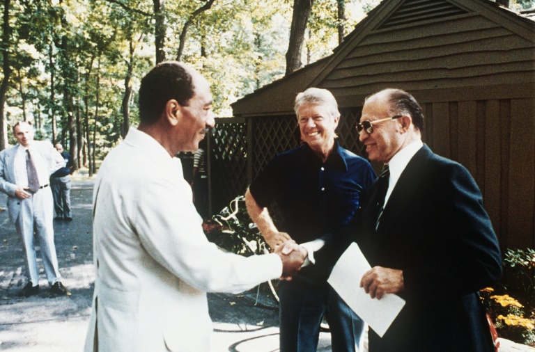 Then US president Jimmy Carter looks on  in September 1978 as Egyptian president Anwar al-Sadat (left) shakes hands with Israeli premier Menachem Begin during negotiations at the Camp David retreat on a historic peace deal