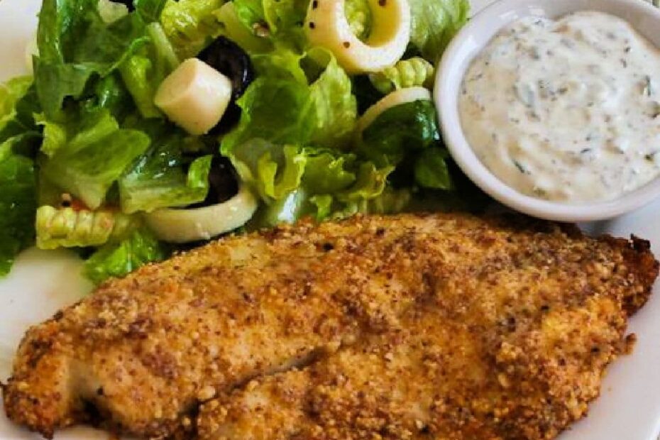 Square image of Almond and Parmesan Baked Fish shown on serving plate with salad and tartar sauce.