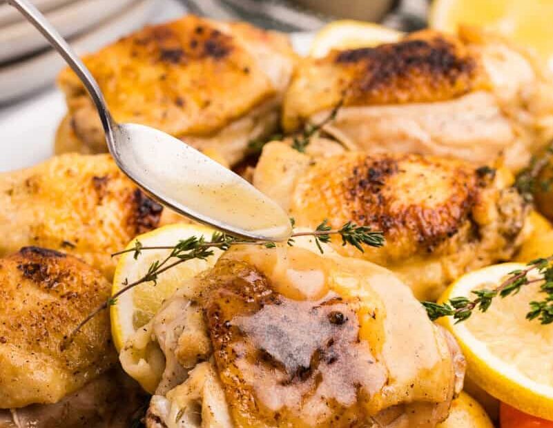 chicken thigh with sauce being poured on top