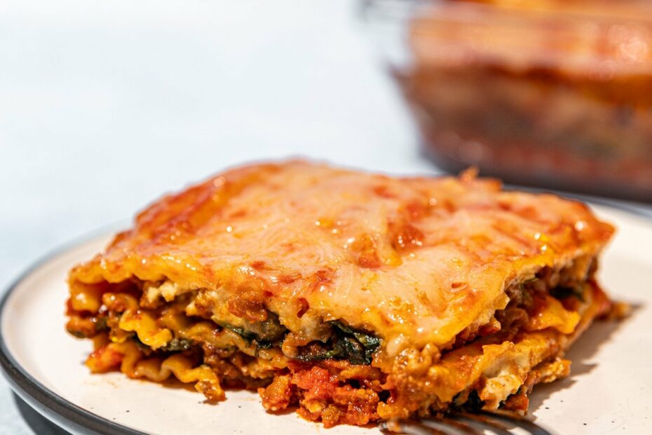 vegan lasagna on white plate with fork