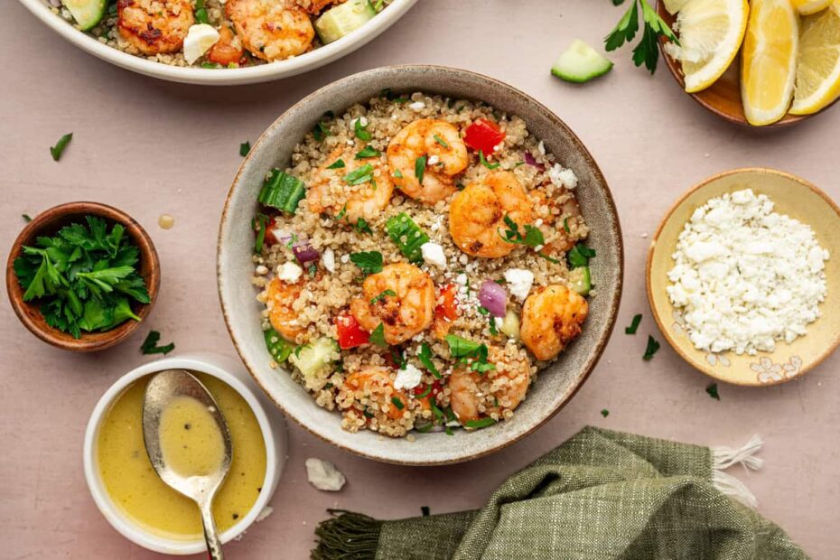 shrimp and quinoa salad in small bowl with dressing on the side