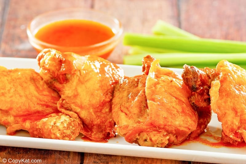 homemade Wingstop Buffalo chicken thighs, celery sticks, and Buffalo sauce.