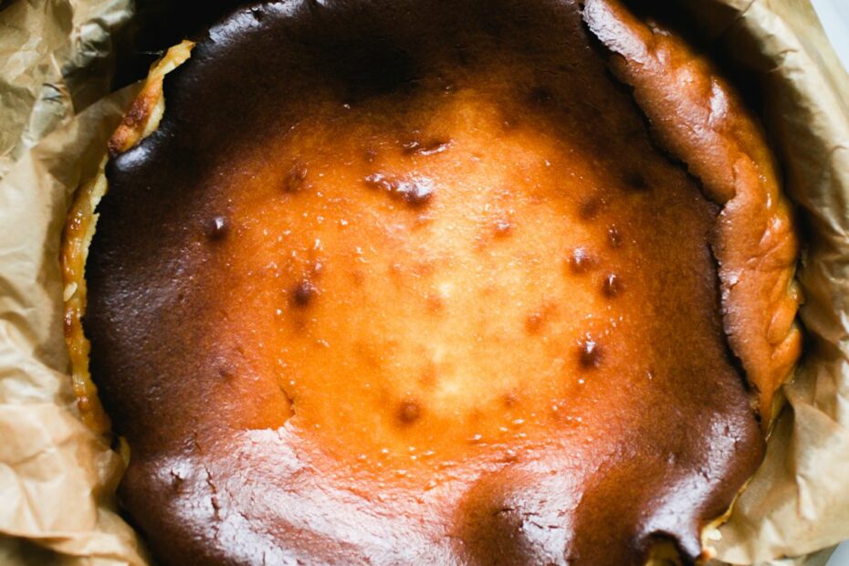 Creamy, homemade, sourdough Basque cheesecake in a parchment-lined pan.