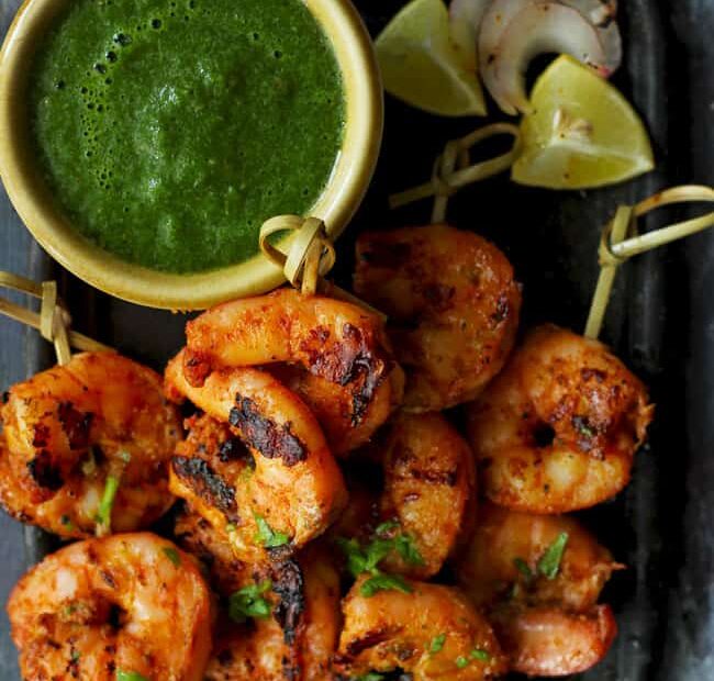 aerial shot of tandoori prawns on a black platter