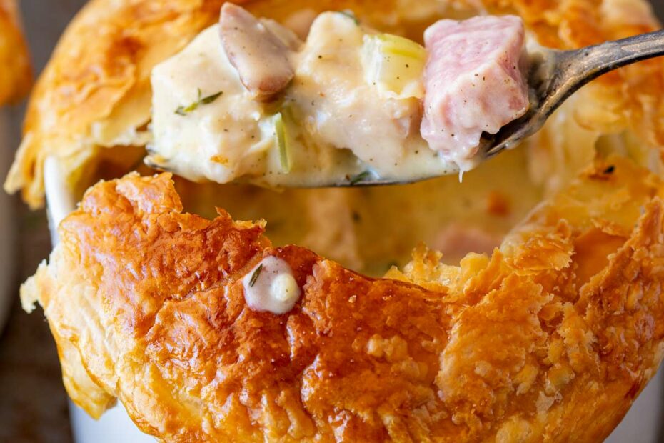 A bowl of Mejadra, with spiced lentils and rice, served in a dark grey bowl on a blue/silver-grey table.