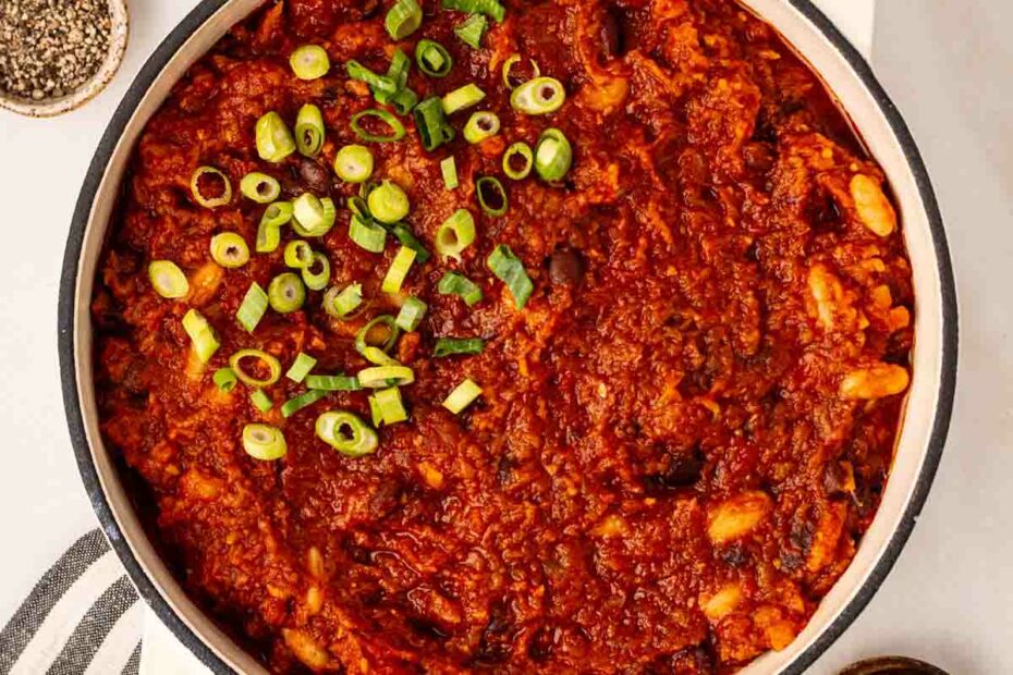 A big pan of Vegan Chilli with spring onions on top, ready to serve.