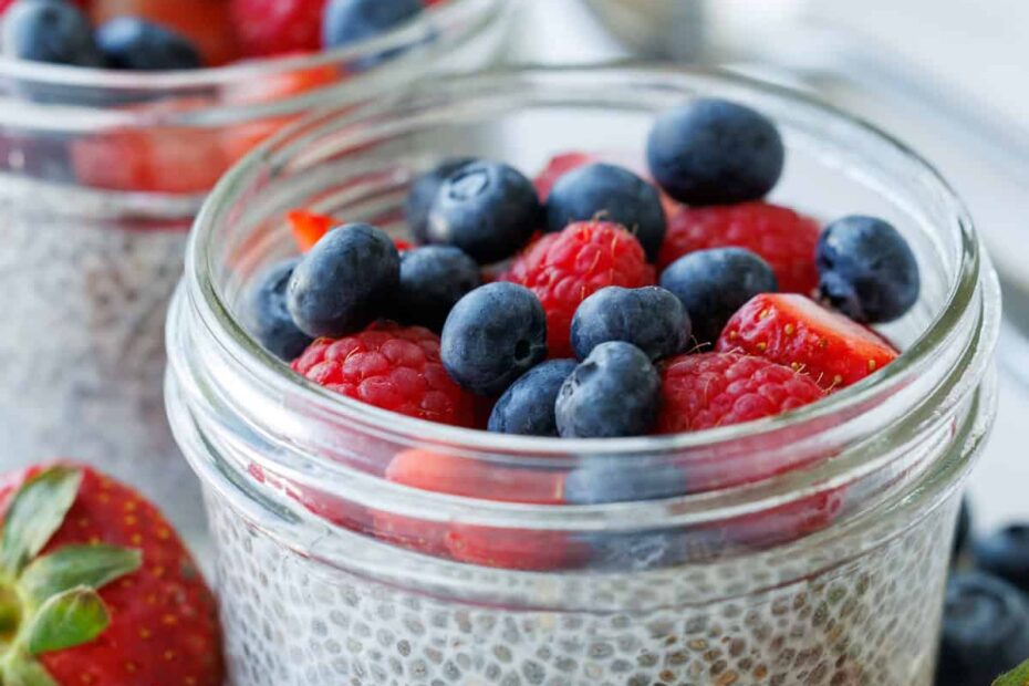Simple chia seed pudding recipe in mason jars with berries on top