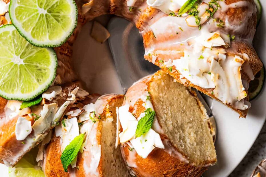Overhead view of a cake server underneath a slice of coconut cake cut from the rest of the cake.