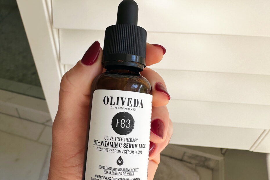 Woman holding bottle of Oliveda Vitamin C serum for the face