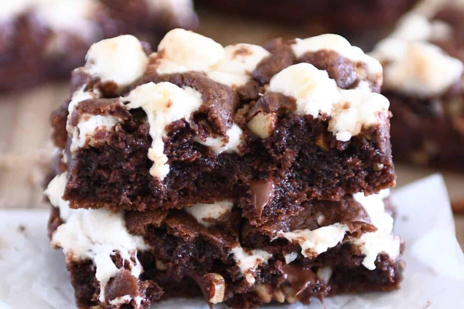 Rocky road chocolate cookie bar split in half and stacked on white parchment paper.
