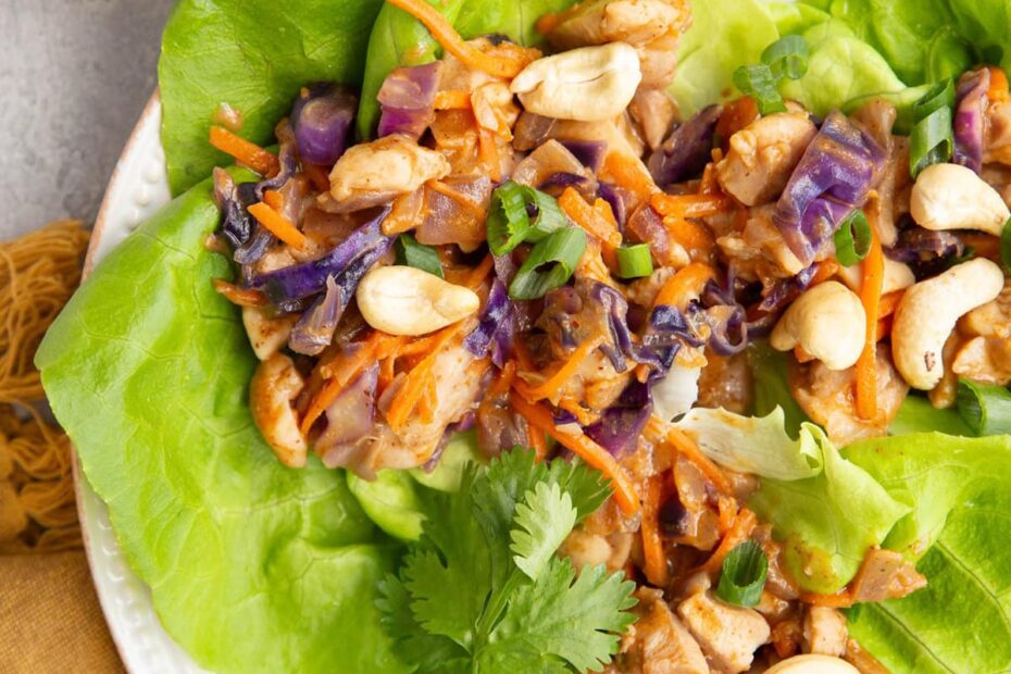 Plate of Thai Chicken Lettuce wraps with a bowl of green onions to the side.