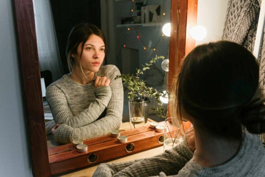 Woman staring into a mirror prepping for confidence boosting mantras