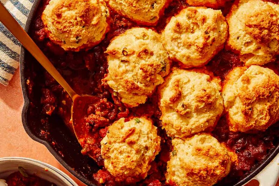 Chili Cornbread Casserole in a skillet with a scoop taken out.