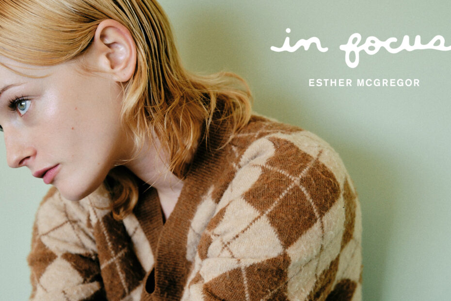 Promo image for Esther McGregor In Focus story. She is looking off-screen wearing a brown and tan argyle sweater. The image reads: In Focus, Esther McGregor.