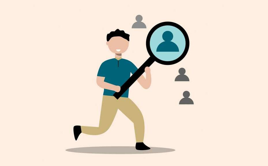 person with magnifying glass enlarging one employee silhouette - concept of finding the right employee