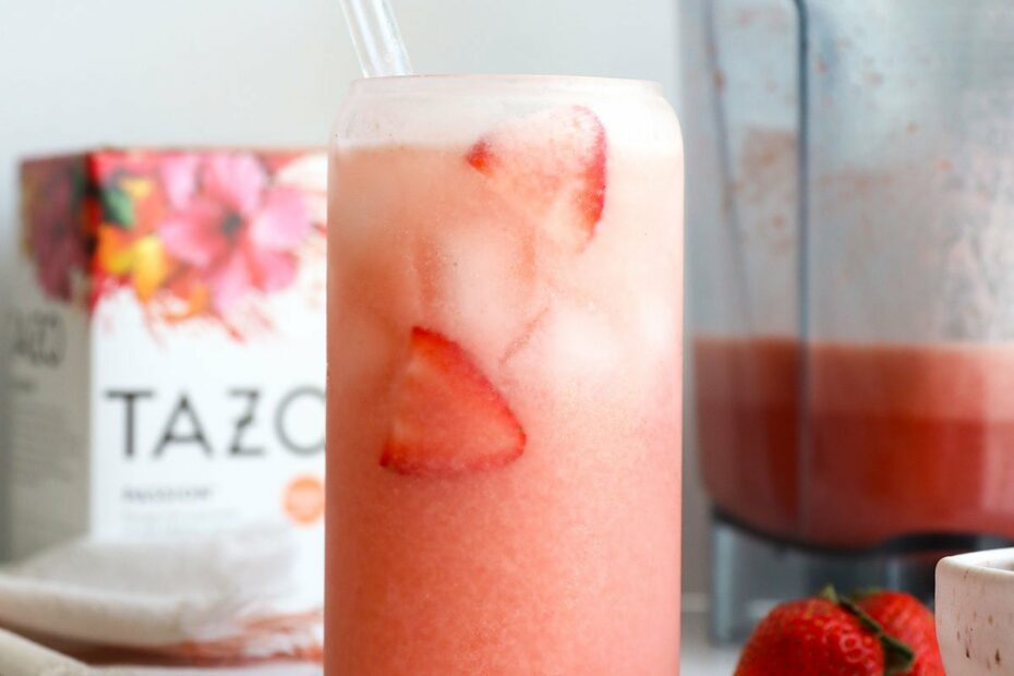homemade pink drink in a glass with fresh strawberries.