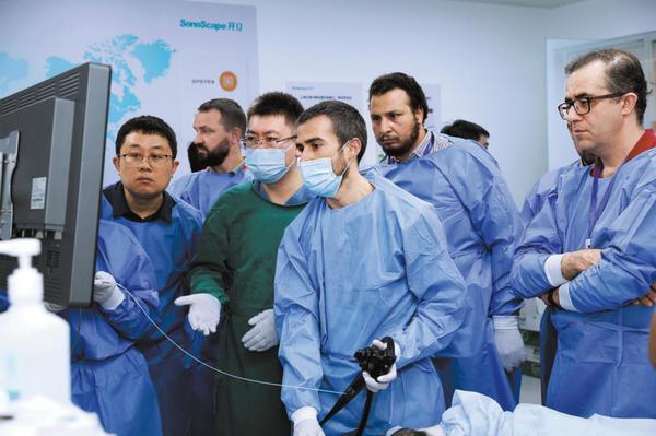  Guided by physician Wei Yongqiu (third from left), Diogo Libanio (center), an attendee of the seventh Belt and Road International Advanced Gastrointestinal Endoscopology Seminar, operates an endoscope on a pig at the Beijing Friendship Hospital affiliated to Capital Medical University in Beijing. [Photo provided to CHINA DAILY]