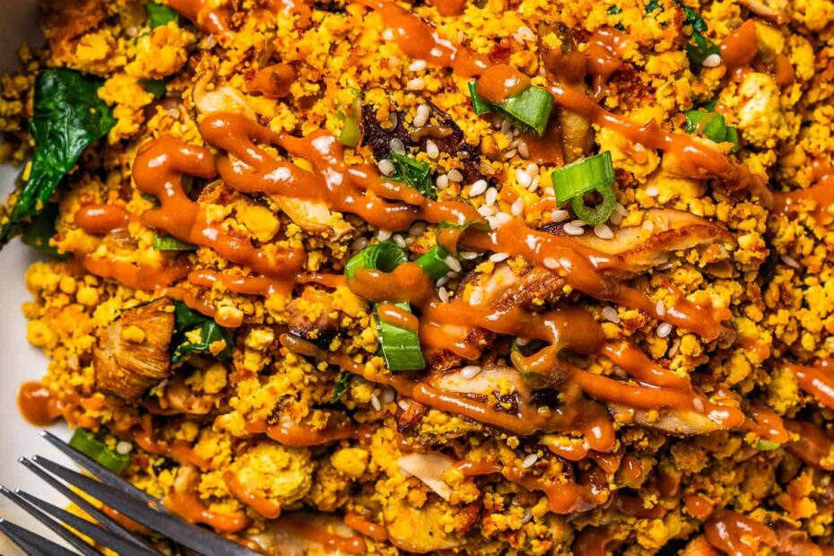 Tofu scramble served in a bowl with a drizzle of peanut sauce on top.