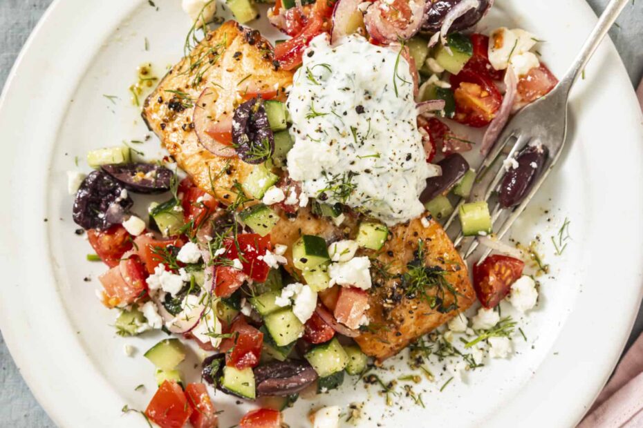 salmon with greek topping on a white plate