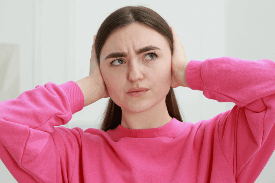 Photo of young woman covering her ears because she doesn