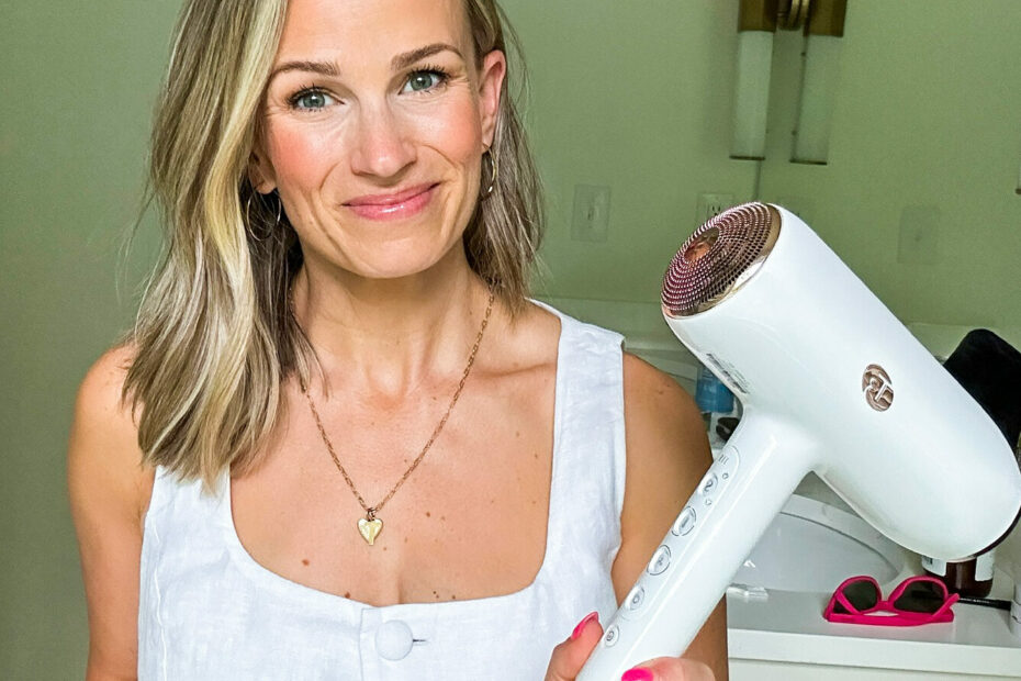Woman with white button up top holding T3 Hair dryer