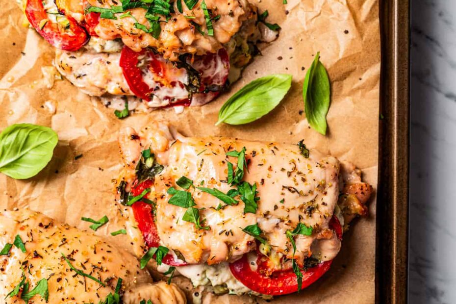 Overhead view of baked stuffed chicken breasts on a parchment-lined baking sheet. Photo by diethood.com