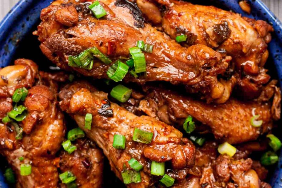 Overhead shot of braised Asian chicken wings, garnished with chopped green onions.