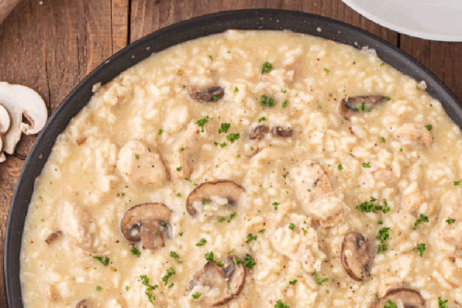 Large skillet of mushroom risotto with chunks of chicken