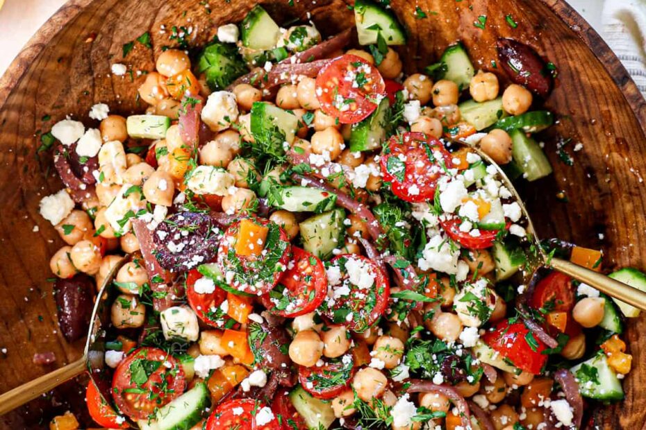top view of tossing garbanzo bean salad in a bowl