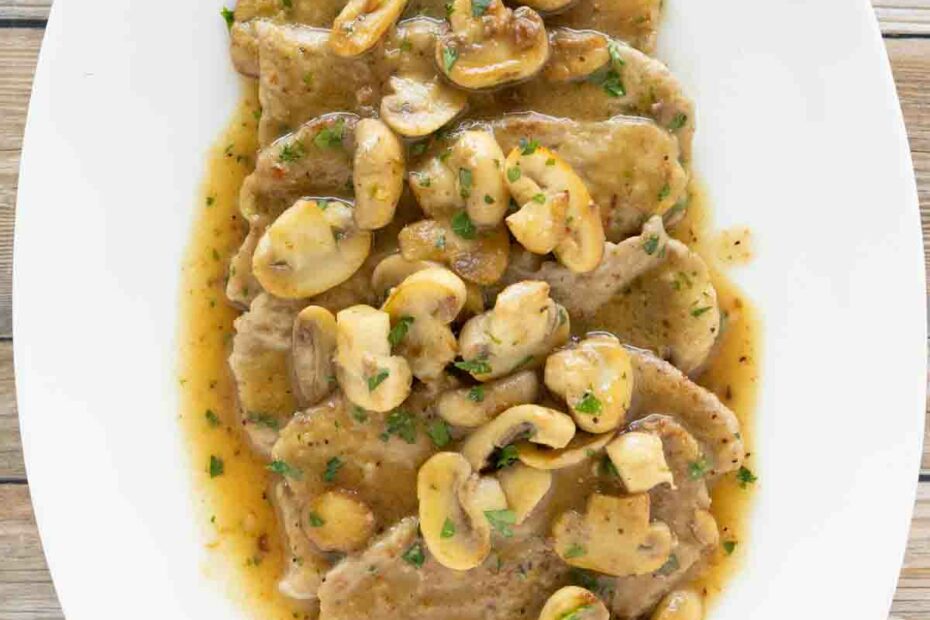Veal scallopini on a white oval platter.