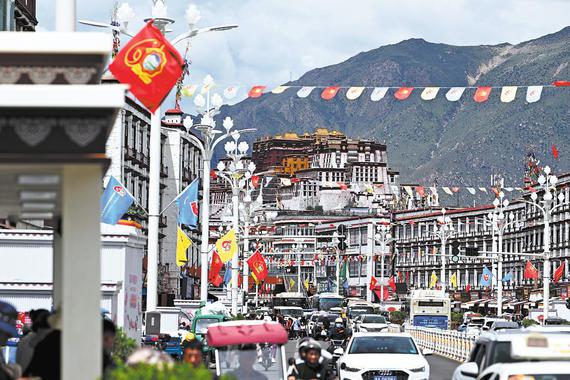 Colorful flags adorn a bustling avenue on Monday in Lhasa, to celebrate the 60th anniversary of the founding of the Xizang autonomous region. (KUNGA LEZANG/CHINA NEWS SERVICE)