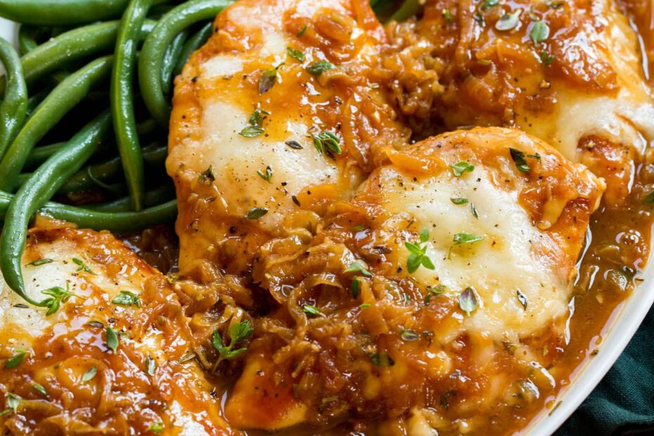 French onion chicken served on a white platter with green beans.