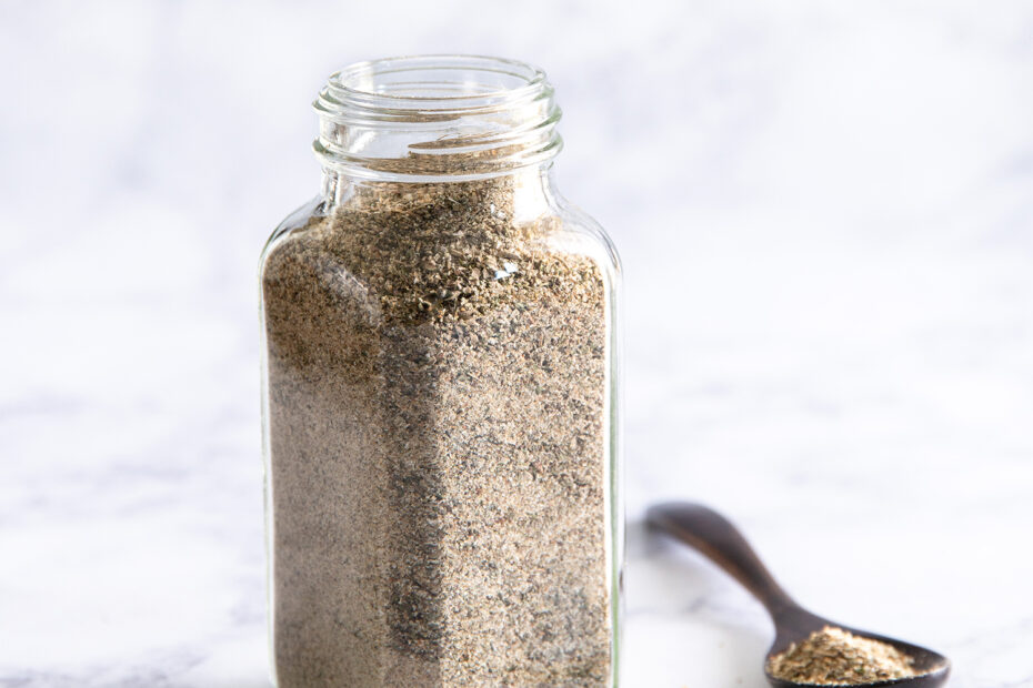 Nutritional yeast free chicky seasoning in a jar with a spoon beside.