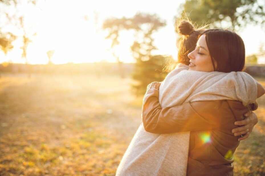 Two women share a warm hug in the evening sun, reflecting the gift of women’s emotions in small churches.
