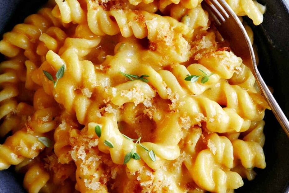A bowl of pumpkin mac and cheese for a fork in the pasta.
