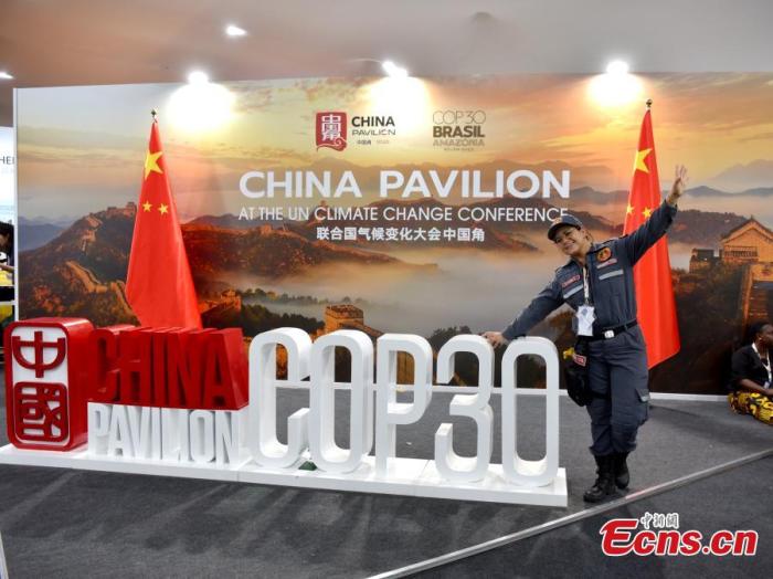 A female security officer takes a picture at COP30 China Pavilion in Belem, Brazil on Nov. 10, 2025. (Photo: China News Service/Lin Chunyin)