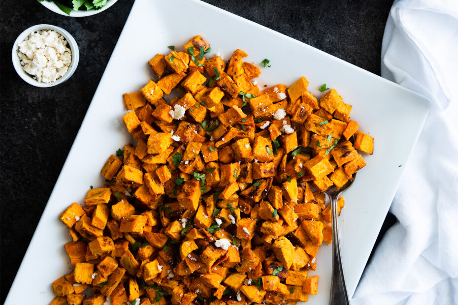 Oil-Free Roasted Sweet Potatoes with cilantro and vegan feta on a serving platter.