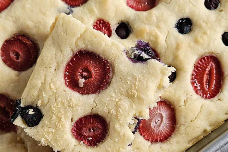 Sheet pan pancake with berries in a metal pan.