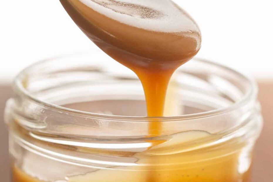 Scooping homemade butterscotch sauce using a spoon