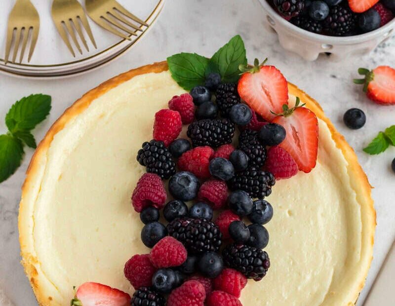 Fresh mixed berries on a cheesecake, perfect for seasonal cravings and summer desserts.