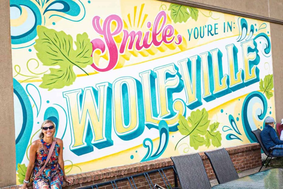 lady in front of wolfville mural