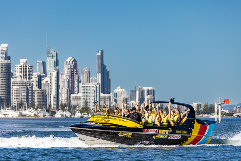 Jet boat driving with guests with hands in the air
