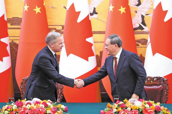 Premier Li Qiang (right) shakes hands with Canadian Prime Minister Mark Carney on witnessing the exchange of multiple bilateral cooperation documents following their talks on Thursday at the Great Hall of the People in Beijing. WANG ZHUANGFEI / CHINA DAILY