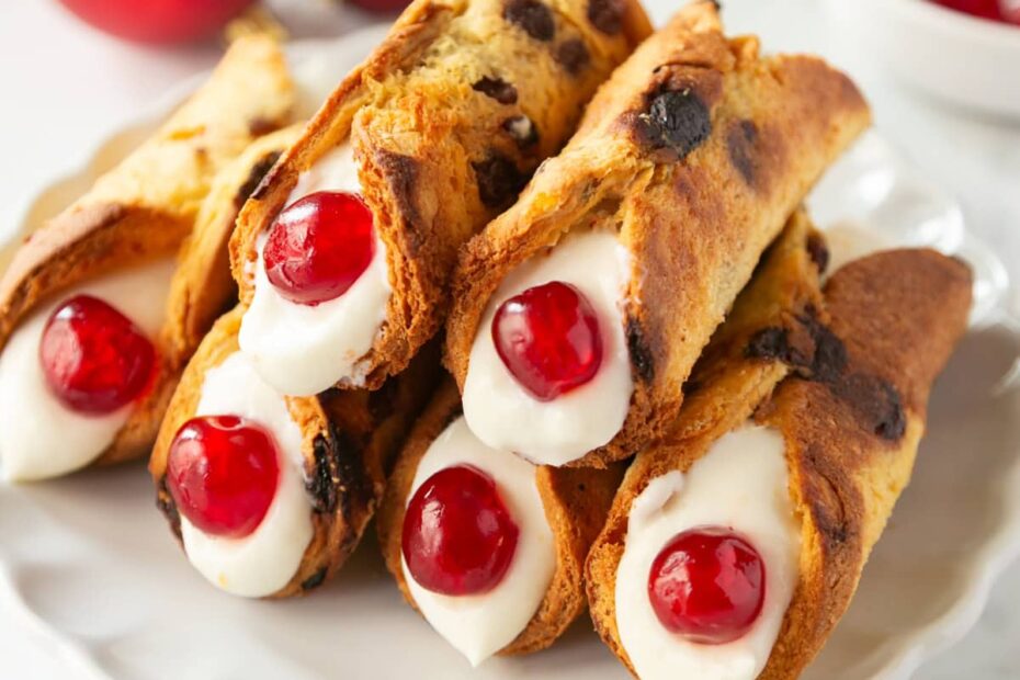 christmas cannoli with panettone shells, filled with ricotta cream and decorated with candied cherries.