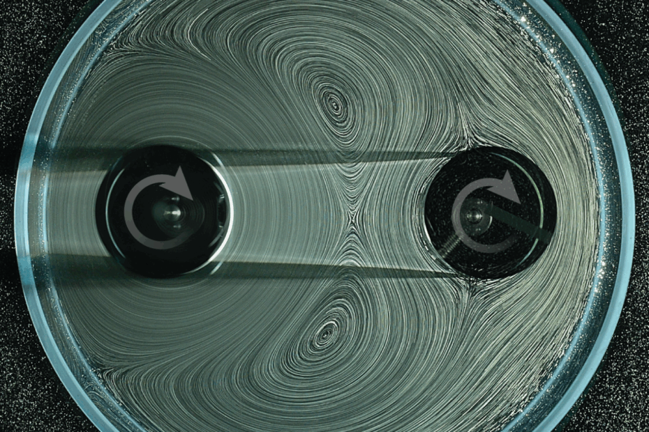 Spinning gears in a fluid with bubbles and arrows showing the direction of the current